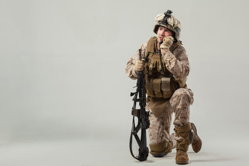 Soldier in camouflage holding rifle