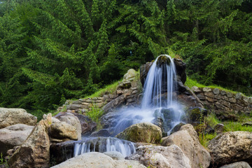 Beautiful artificial waterfalls, in the background are green pine trees. (izvorul minunilor)...