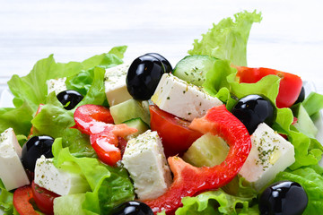 Greek salad on a white wooden background. Space for text or design.