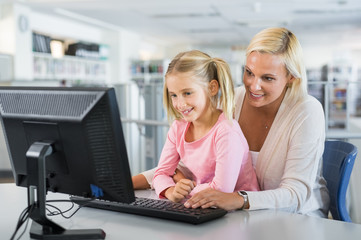 Mother and girl using computer