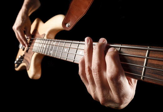 hands of rock bassist playing bass