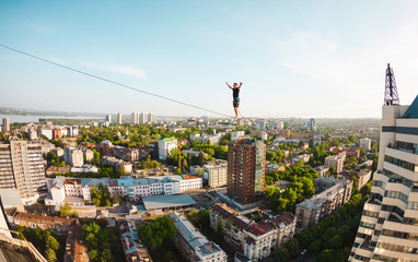 The man is balancing over the city.