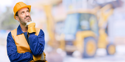 Senior engineer man, construction worker thinking and looking up expressing doubt and wonder at work