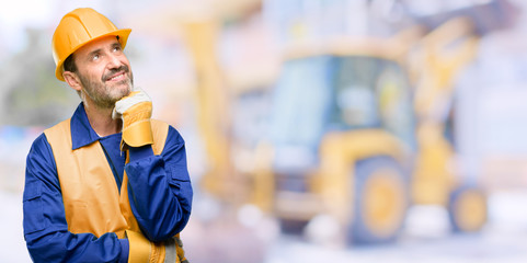 Senior engineer man, construction worker thinking and looking up expressing doubt and wonder at work