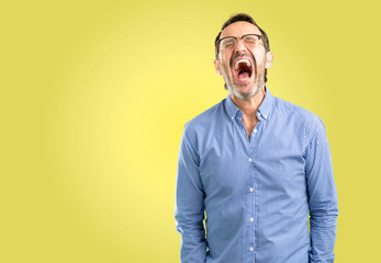 Handsome middle age man stressful, terrified in panic, shouting exasperated and frustrated. Unpleasant gesture. Annoying work drives me crazy