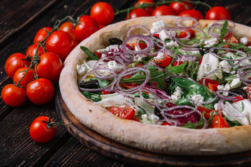 Whole vegeterian pizza on wood background.