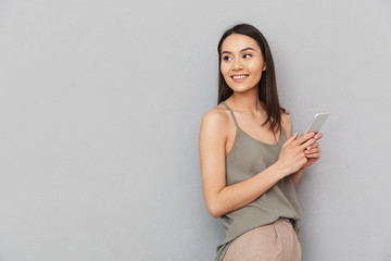 Portrait of a smiling asian woman holding mobile phone