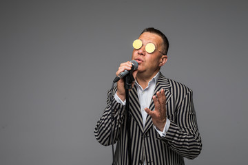 Mid age man in suit singing over the microphone with energy. Isolated on white background. Singer...