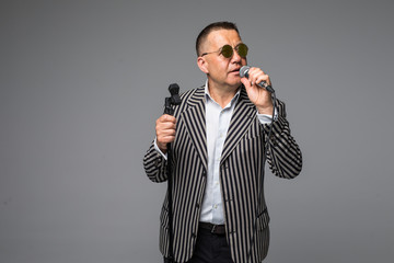 Mid age man in suit singing over the microphone with energy. Isolated on white background. Singer...