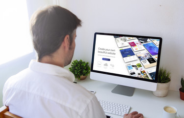 man browsing website builder on computer