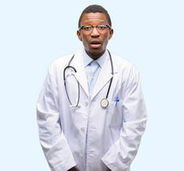 Young black doctor, medical professional scared in shock, expressing panic and fear