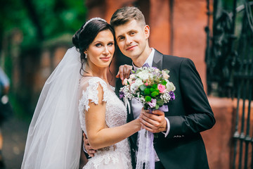 Happy Bride and groom embracing  in the old city in Europe. wedding concept.   Groom with elegant...