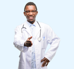 Young black doctor, medical professional holds hands welcoming in handshake pose, expressing trust and success concept, greeting