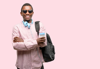African black man student with crossed arms confident and happy with a big natural smile laughing