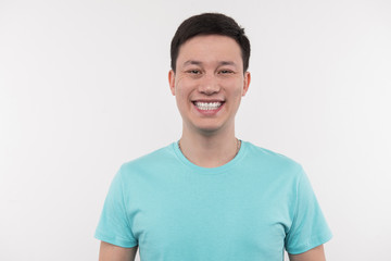 Positive and friendly. Cheerful delighted man smiling to you while standing against white background