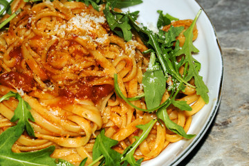 Spaghetti with tomato sauce on the wooden table