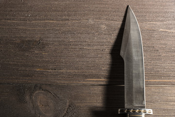Hunting knife on a wooden background