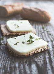 Crisp bread with cheese and thymeon the wooden table, rustic style