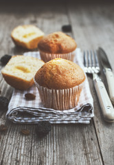 Freshly baked muffins with cream on the wooden table, rustic style