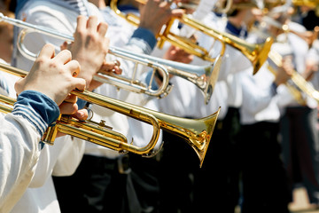 Closeup of children's brass band. Children play on golden pipes.