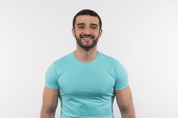 Fototapeta premium Facial expression. Joyful bearded man smiling to you while being in a good mood