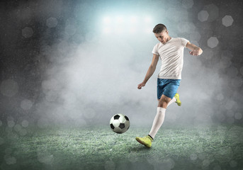 Soccer player on a football field in dynamic action at summer day