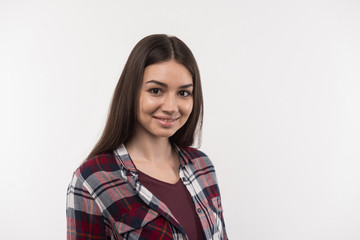 Positive smile. Pleasant delighted woman smiling to you while standing against white background