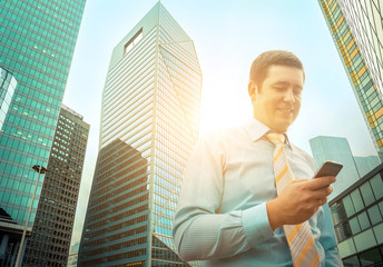 Businessman. Happiness businessman with phone around skyscrapers