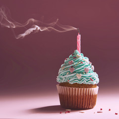 muffin with cream and extinguished candle. the concept of the end of the celebration.