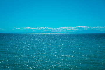 beautiful blue sea with fluffy white clouds