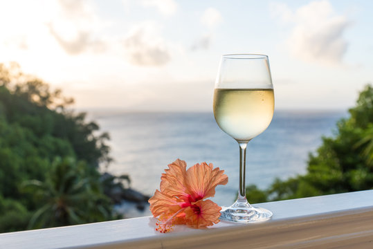 Fototapeta Romantic moments in summer at sunset with two glasses of white wine - Relaxing romantic holiday concept with beautiful view of tropical beach and coast
