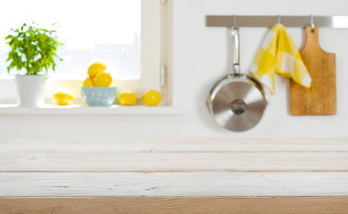 Blurred kitchen interior background with wooden table top in front