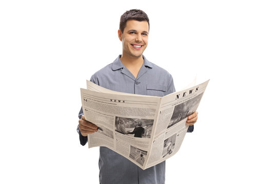 Young man in pajamas holding a newspaper