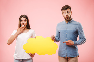 Portrait of a shocked young couple pointing finger