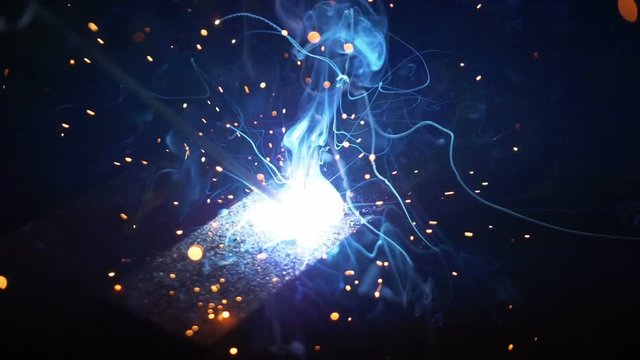 Professional video of close shot of a welder welding pieces in slow motion 180fps