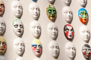 Carnival masks hanging on wall boards lie