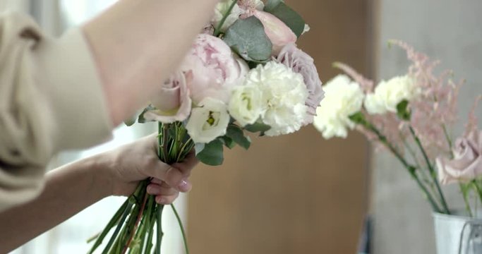 Young Florist Assembles a Rustic Wedding Bouquet. She's happy to have small business