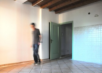 Inside the room during renovations with blurred worker figure. Architectural background.
