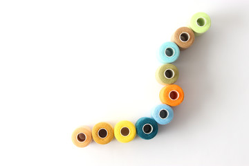 sewing thread of different colors isolated on white. top view 
