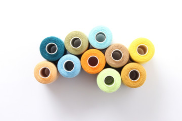sewing thread of different colors isolated on white. top view 