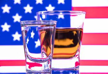A glass of vodka and a glass of brandy, whiskey or bourbon on a white or colored background