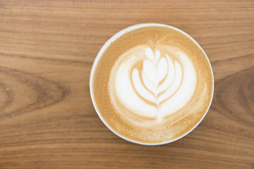 Latte art hot coffee top view.Coffee art on wooden table background.