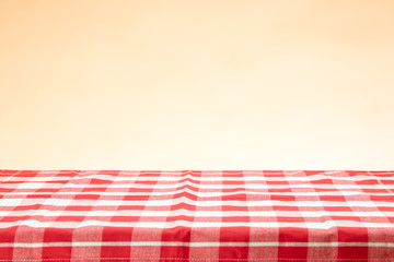 An empty table with a red checkered tablecloth and an bright background. For your food and product...