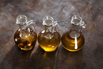 Fototapeta Oliwa z oliwek. Kompozycja buteleczek  z oliwą na czarnym tle obraz