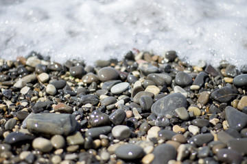 Glitter of stones in sea waves