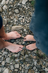 Two pairs of bare feet stand on stones and receive vital energy
