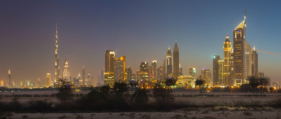 Fototapeta na wymiar DUBAI, UAE - MARCH 31, 2017: The evening skyline of Downtown with the Burj Khalifa and Emirates Towers.