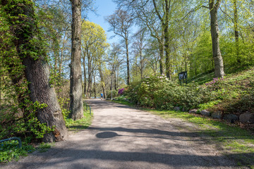 Unrecognizable people enjoy a walk and spring atmosphere in the city park along Motala river in Norrkoping, Sweden.  