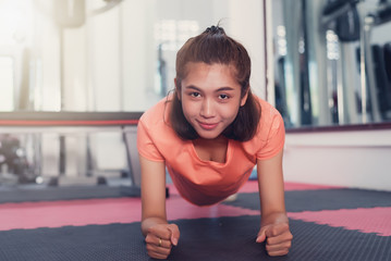 Fototapeta premium Woman doing plank exercise in Gym