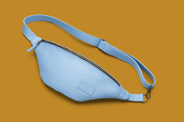 Light blue leather waist bag on the orange background